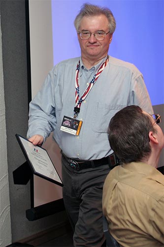 Jim Plaxco leaving the stage award in hand.